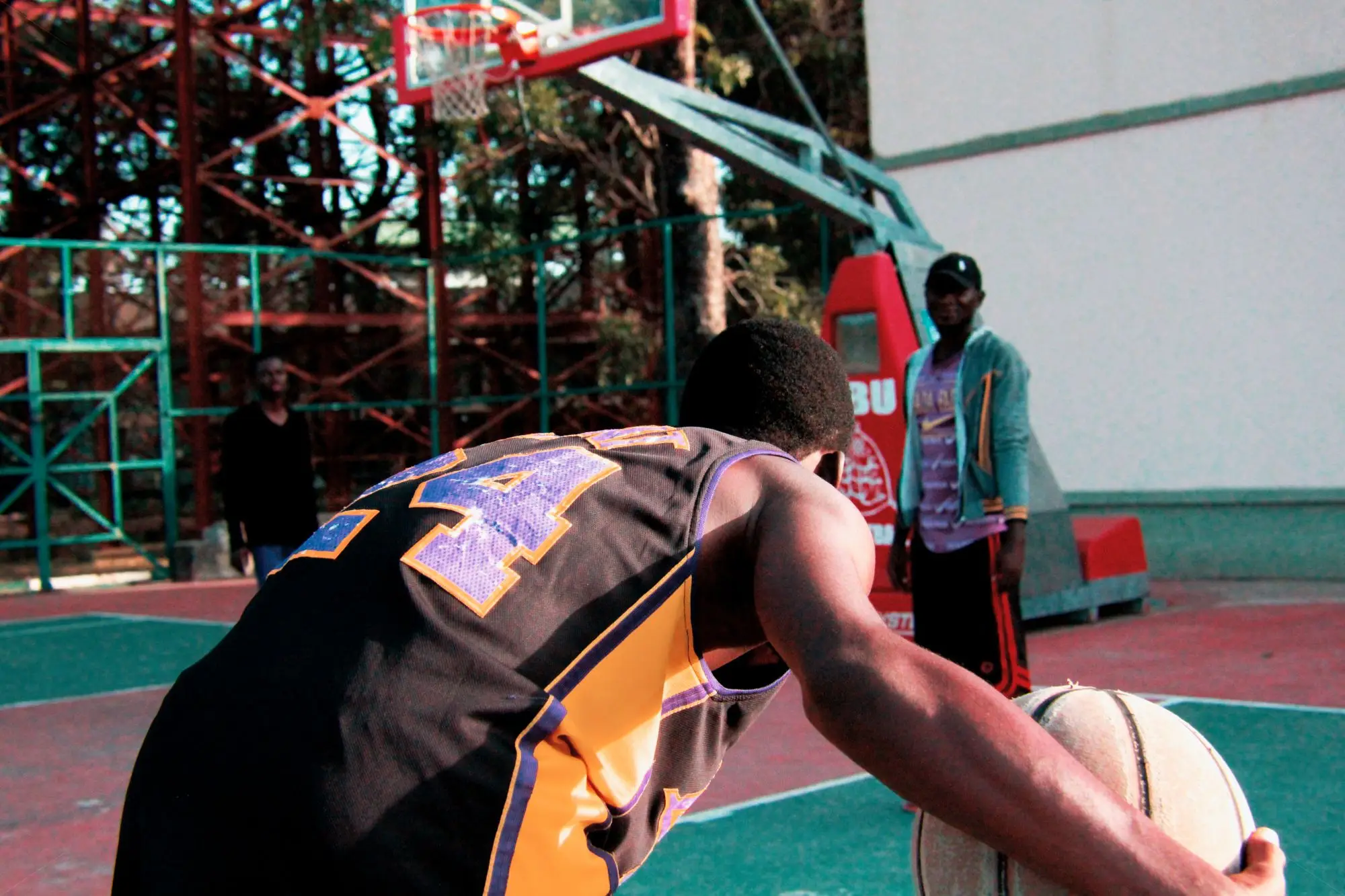 A player driving to the hoop on an outdoor basketball court