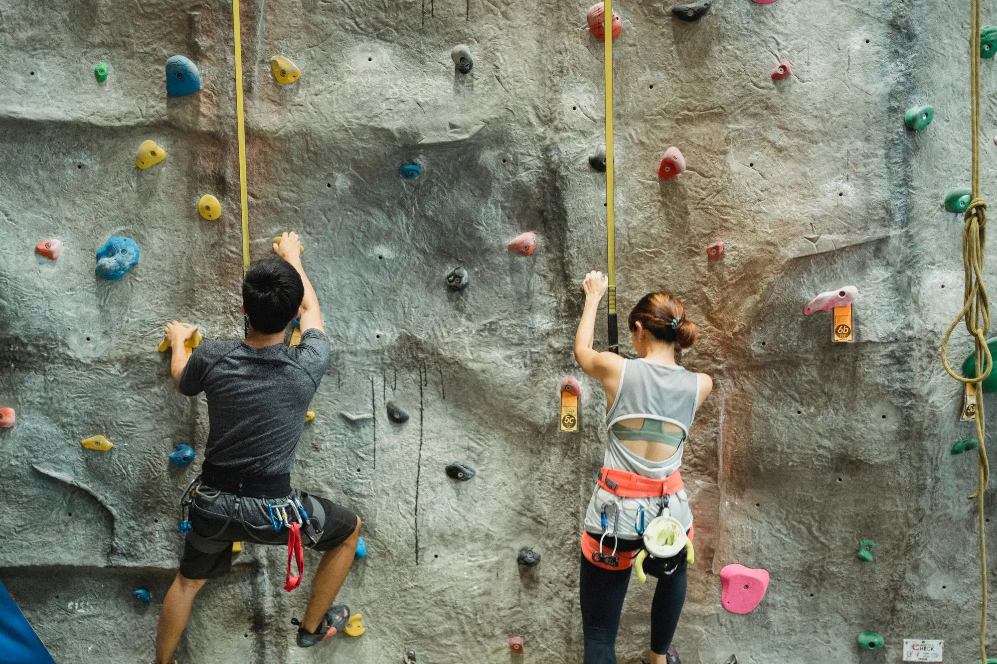 Two climbers roped up on a climbing wall