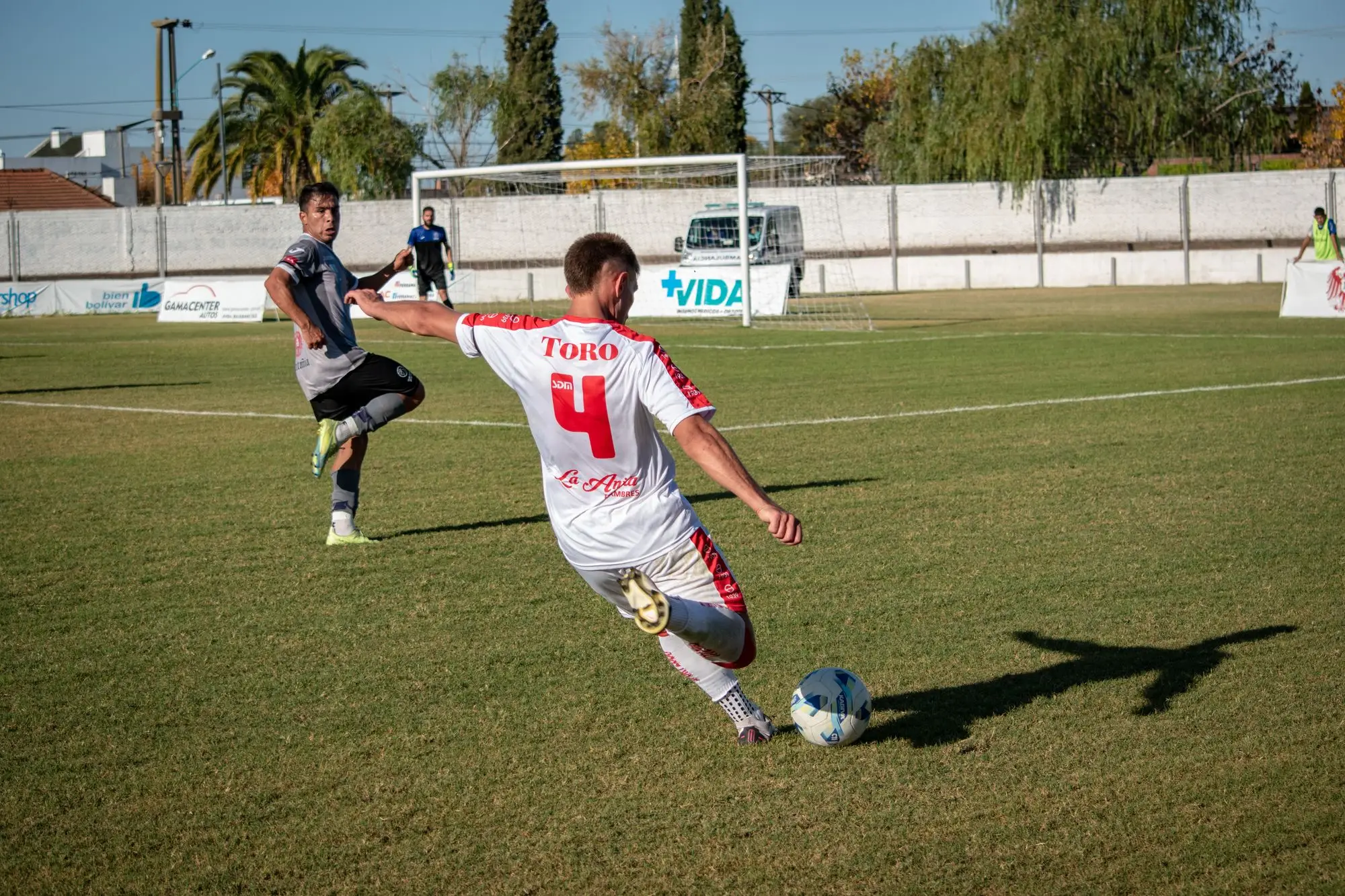 Players in an amateur football match on a local pitch