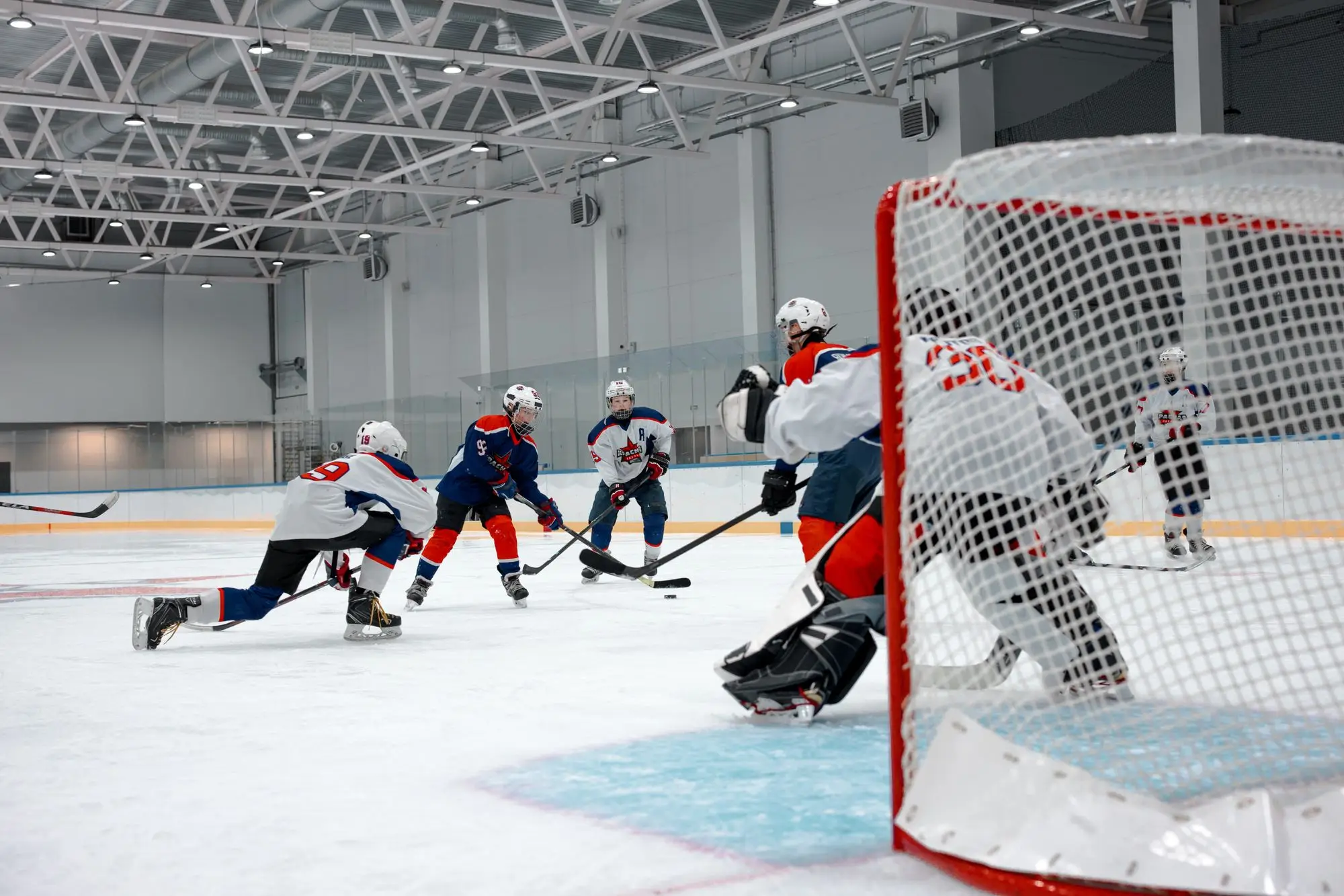 Ice hockey players converging on the net in a rink